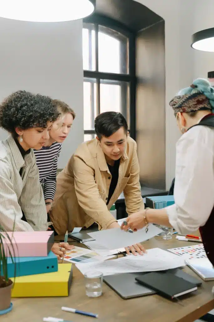 Les appels d'offres événementiels : nos recommandations pour y répondre Équipe d'agence événementielle réunie autour d'un plan de travail pour construire une réponse à un appel d'offres